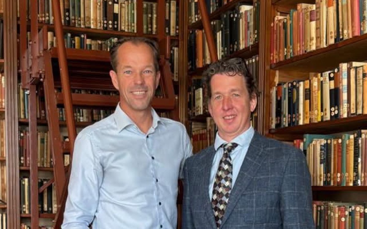Twee personen in de bibliotheek van Sociëteit De Witte
