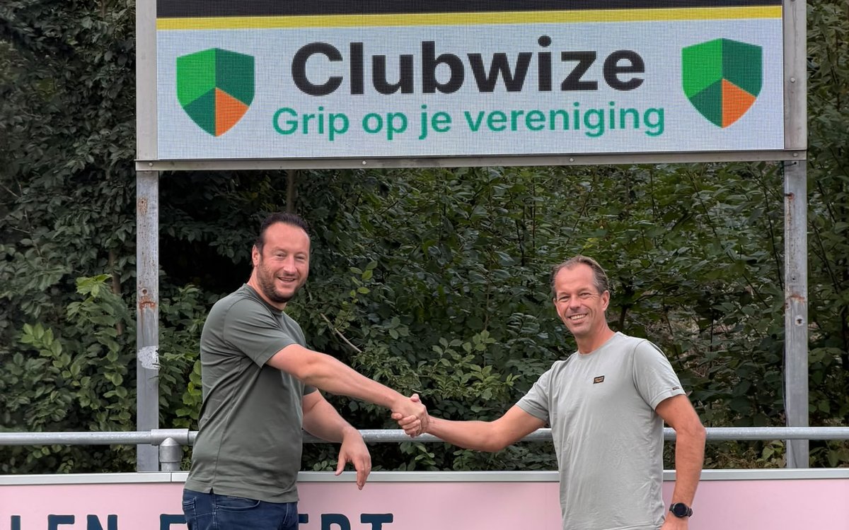 Handdruk onder het nieuwe scorebord van vv Wilhelmus met Clubwize-reclame