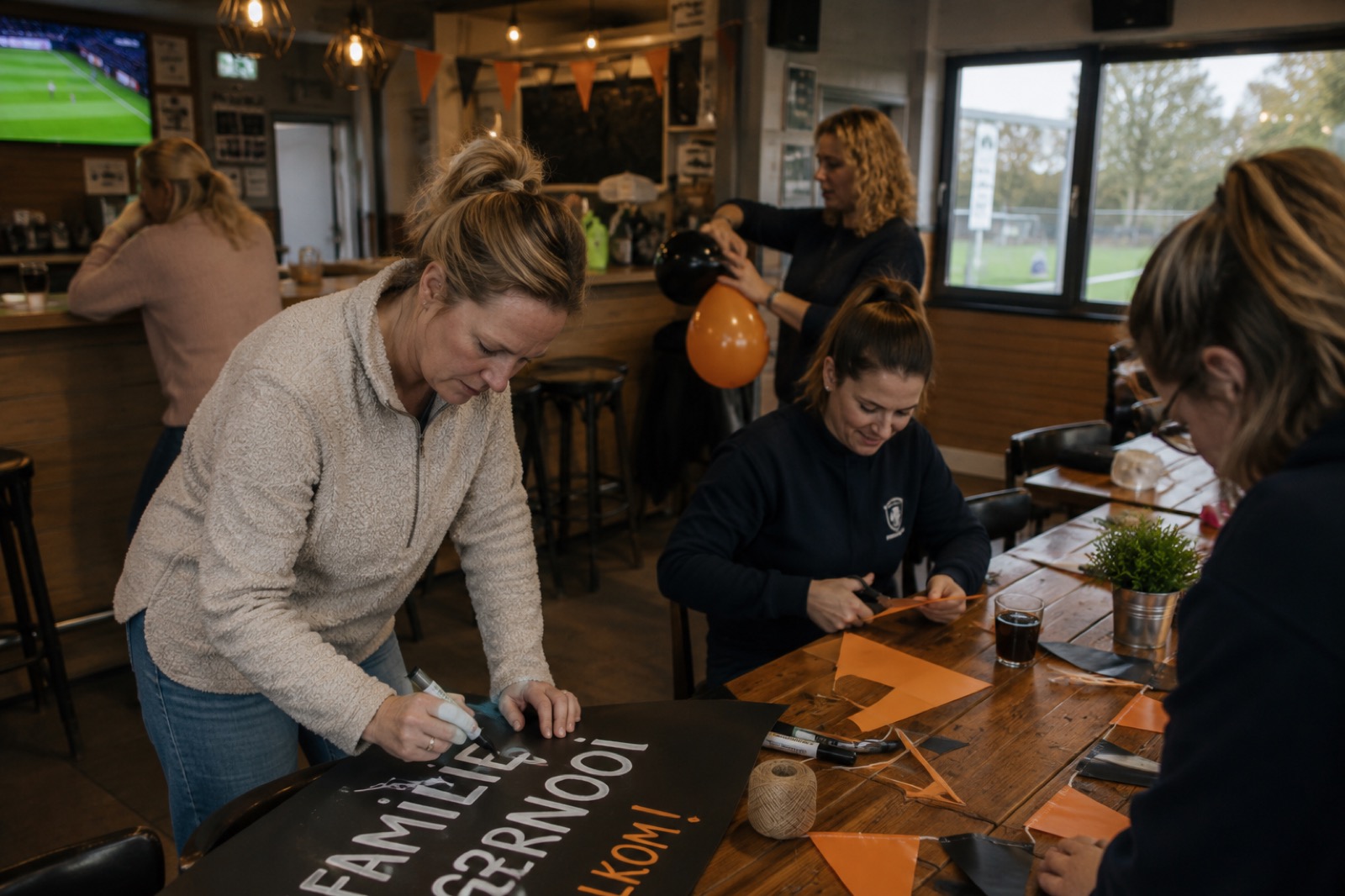 Een groep schrijft op een bord en knipt slingers voor een feestelijke versiering